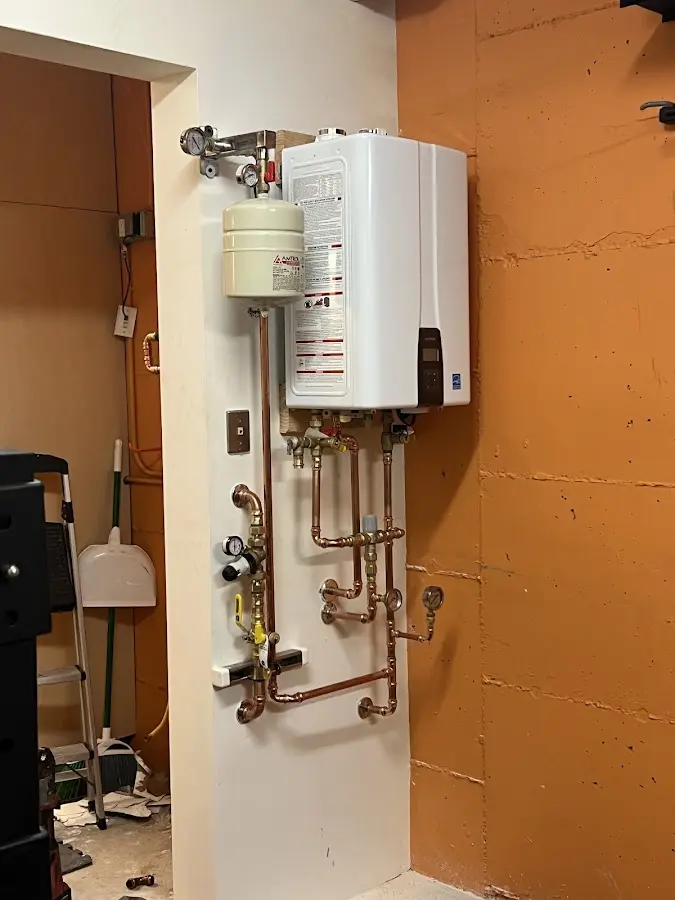 Plumbing technician inspecting water heater connections in Glenview